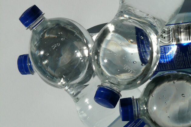 Acqua in bottiglie di plastica esposte al sole